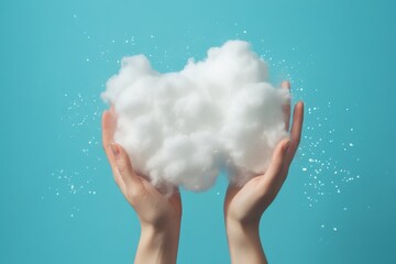 Two hands holding a fluffy white cloud against a sparkling blue background symbolizing cloud storage