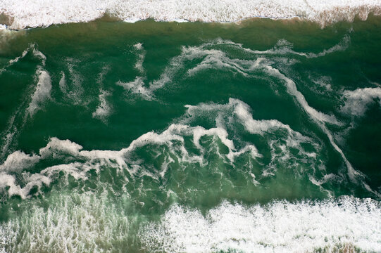 Aerial view of The waves of the Atlantic Ocean break at the desert coast south of Walvis Bay. Aerial view. Namib-Naukluft Park, Namibia.