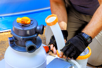 Maintenance worker assembles sand filter system tank well as cleaning equipment for swimming pools