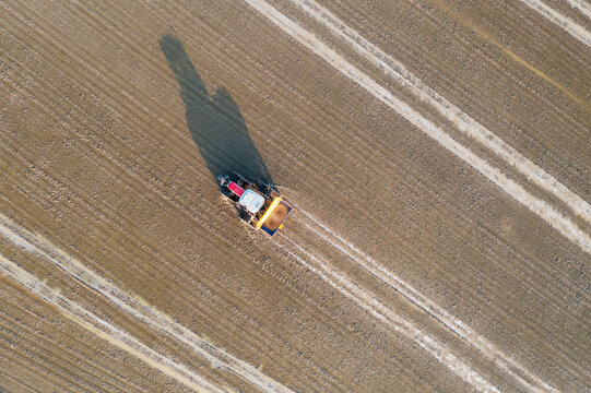 Aerial view of Tractor sowing rice seeds in a flooded rice field in May. Ebro Delta Nature Reserve, Tarragona province, Catalonia, Spain.
