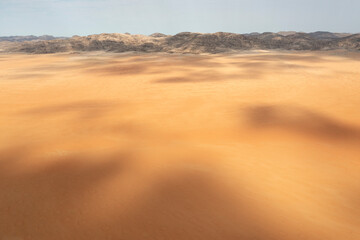 Aerial view of Sandy desert plain and bare mountain ranges, aerial view, drone shot, Kaokoland, Kunene Region, Namibia.