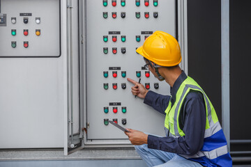 Electrical engineer man using tablet checks switchboard main Distribution Boards control panel...
