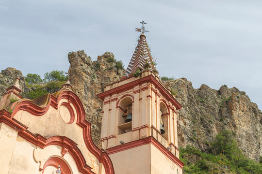 View of historic church with bell tower and picturesque facade on a hillside, Zahara, Spain.