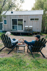 Retired couple enjoying cheese and wine by the fire at a tiny house in the Western Australia bush