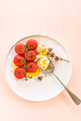 Baked tomatoes with feta cheese and aromatic herbs seasoned with extra virgin olive oil on a spoon. Summer Mediterranean lunch, Greek light cuisine. Dietary balanced nutrition, close up