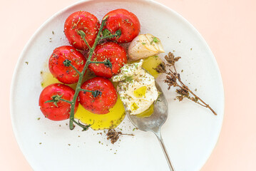 Baked tomatoes with feta cheese and aromatic herbs seasoned with extra virgin olive oil. Summer...