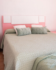 Double bed with pillows in interior of the modern bedroom in loft flat in light color style of expensive apartments.