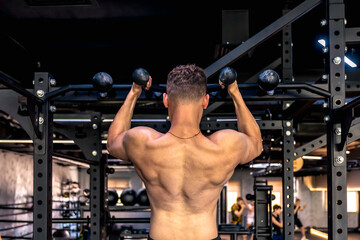 Back view of a man doing push-ups in the gym. Sports lifestyle.