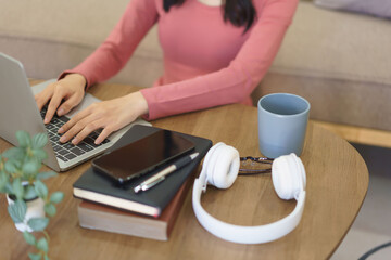 Fototapeta premium Young businesswoman thinking new project and typing business report on laptop while working at home