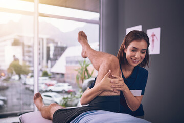 Physiotherapist, man and legs for stretching at clinic, rehabilitation and specialist for helping. Woman, chiropractor and patient for injury assessment, joint recovery and support with treatment