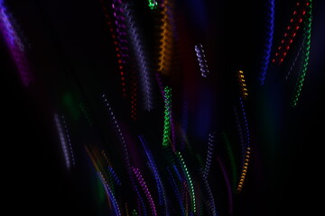 Una toma de cerca de varias luces de colores en movimiento en la oscuridad. Movimiento de cámara