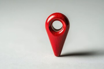 Close-up of a red location pin on a smooth gray surface, symbolizing navigation, travel, and destination. Minimalist and modern design.