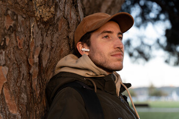 A man enjoys listening to music in the park outdoors