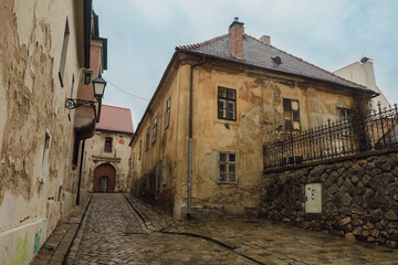 Charming narrow street lined with historic buildings in Bratislava on a cloudy day inviting exploration and discovery of the city's past