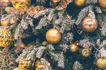 Gold Christmas decorations on the Christmas tree close-up.