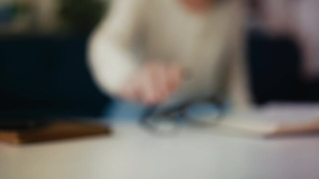 Woman with poor eyesight trying to find eyeglasses on desk, health problems