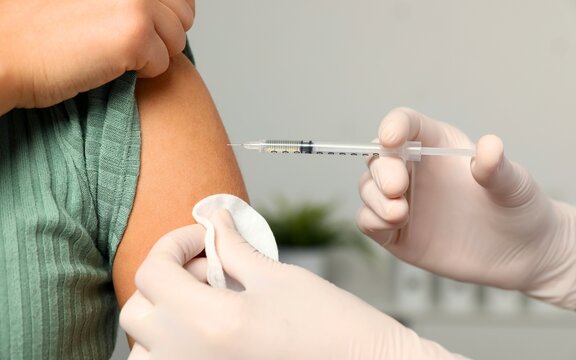 Health care, corona virus, hand of woman nurse, doctor giving syringe vaccine, injection dose on arm sick patient at clinic. Vaccination, immunization disease prevention against flu pandemic influenza