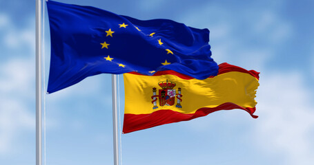 National flag of Spain waving with the European Union flag on a clear day