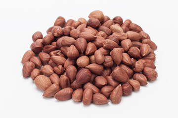 Pile of hazelnuts on white background.