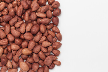 Pile of hazelnuts on white background with copy space.