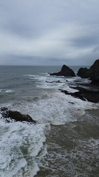 Stunning 4K drone footage flying over the Atlantic Ocean at Odeceixe Beach on Portugal&rsquo;s Vicentine Coast, with breathtaking views of the cliffs and the iconic rock formation in the background