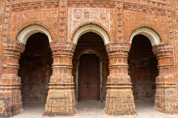 Entrance arch columns decorated with terracotta carvings in Pancha Ratna Govinda Temple, Rajshahi...
