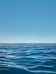 Fototapeta premium A serene seascape with a crystal-clear blue sky meeting the tranquil ocean horizon. The gentle waves, vastness, and clear blue hues evoke a sense of peace, serenity, and the beauty of nature.