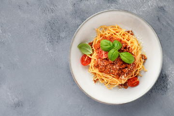 Traditional italian food - spaghetti bolognese with fresh basil leaves and parmesan cheese. top view