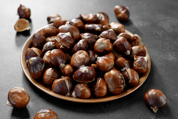Delicious roasted edible chestnuts on a metal plate