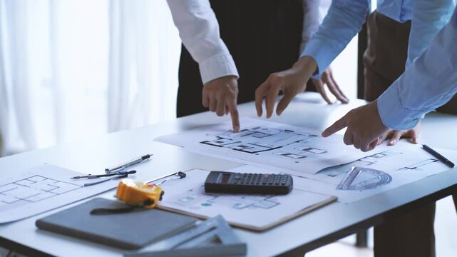 Blueprint to Success: Architects meticulously pore over blueprints, their hands guiding the vision of a new project in this captivating image of collaboration and precision. 