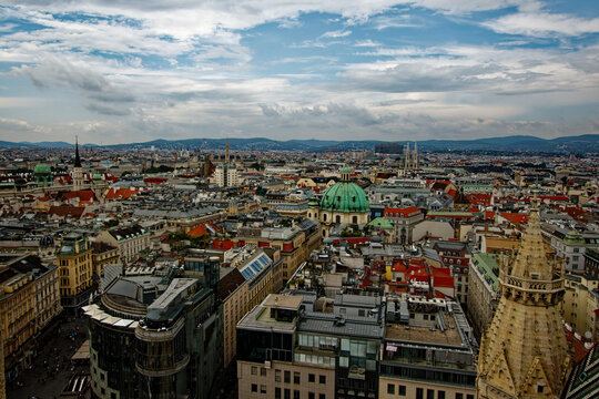 A dense European cityscape reveals historical architecture and majestic cathedral domes under a cloudy sky. This sweeping urban panorama inspires wanderlust and celebrates timeless cultural heritage.