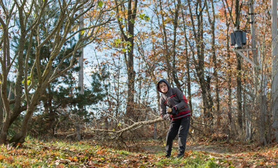 A teenage boy burns autumn leaves on a country plot