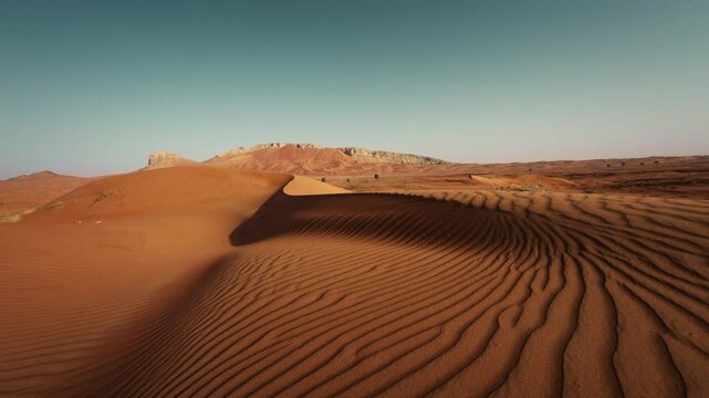 Scenic view of dunes and mountains in Fossil Rock United Arab Emirates during sunset