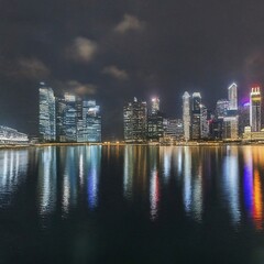 Naklejka premium Singapore skyline reflecting on water at night