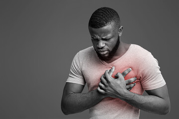 Young african man having heart ache, holding hand on chest. Heart attack or stroke, copy space