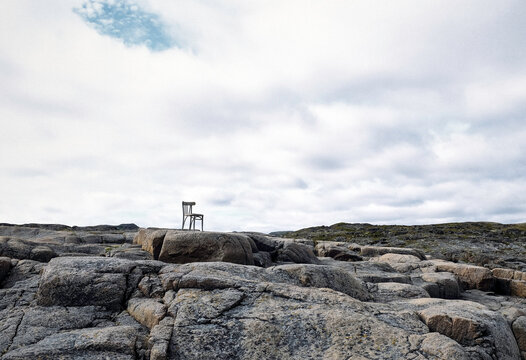 Lone White Wooden Chair Stands on Rugged Coastal Rocks. Solitude, searh concept