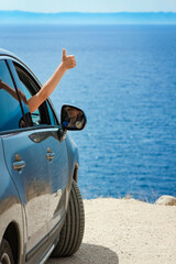 A happy girl from car at sea greece background