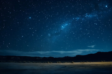 Fototapeta premium Night sky filled with twinkling stars and the Milky Way, above a calm desert landscape