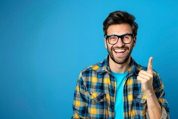 The beautiful male plumber with eyeglasses is happily making a call me gesture, smiling and laughing.