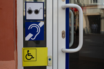 Information panel near entrance to building on street with signs for people with disabilities....