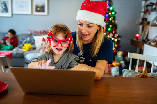 Mom and kid doing Christmas online shopping with laptop and credit card