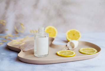 Vitamin C face cream and tonic  with lemon slices on shadows background 