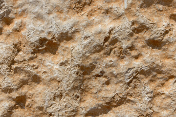 The rough texture of Jerusalem stone with an orange hue.