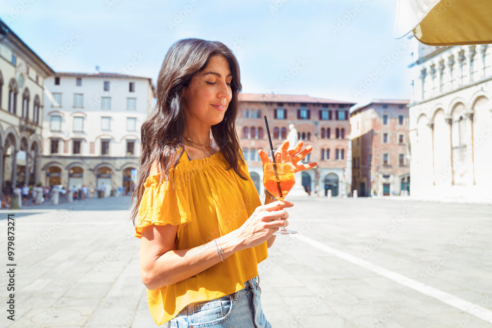 Wall mural beautiful young woman drinking aperol spritz in italy