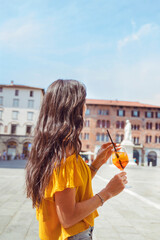 Beautiful young woman drinking aperol spritz  in Italy 