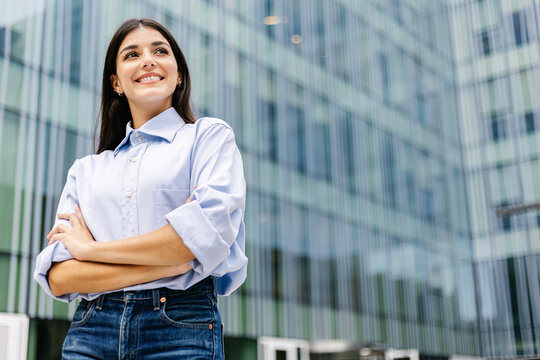 Successful professional boss businesswoman standing over corporate office building. Portrait of empowered female outdoors. Success, work motivation and career vision concept. Copy space.