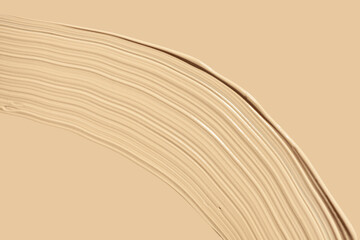 Texture of smudge cosmetic bb or cc cream foundation liquid isolated on beige background