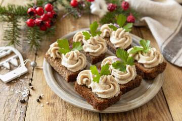 Christmas appetizer New year meal idea. Creative appetizer christmas. Creamy pate sandwiches of herring on a rye bread on the rustic table.