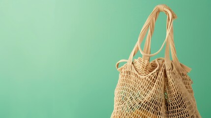 Fototapeta premium Eco Friendly Mesh Shopper on Green Background Sustainable Plastic Free Lifestyle Concept