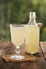 Fresh natural whey in a glass and bottle outdoors